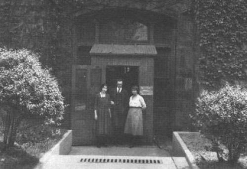 Black and white image of three members of the Psychological Clinic at the entrance, ca. 1923.